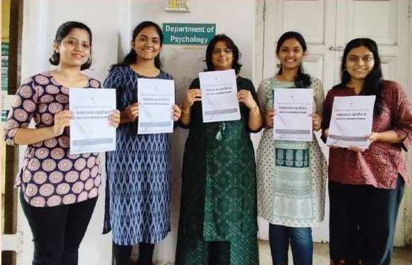 India – psychology students holding newsletter